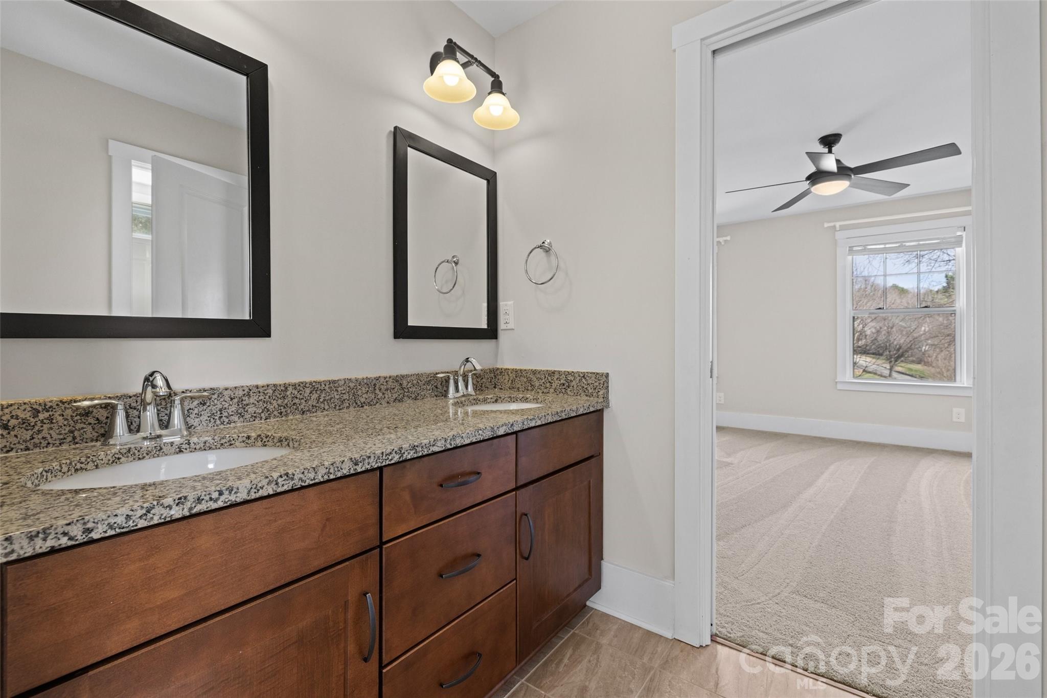 12039 Spinnaker Drive Tega Cay, SC 29708 - Photo 24 of 48 a bathroom with a granite countertop sink a mirror and a