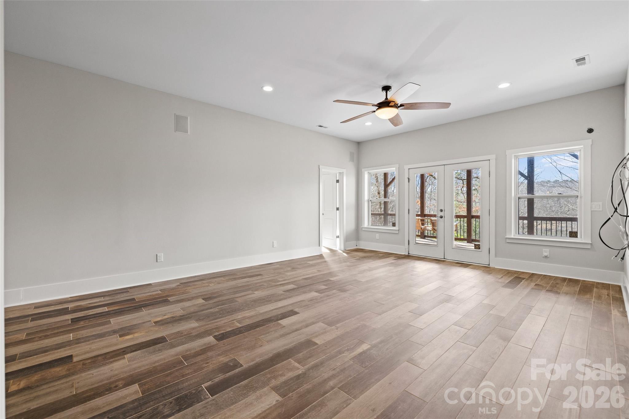 12039 Spinnaker Drive Tega Cay, SC 29708 - Photo 31 of 48 a view of an empty room with a window and wooden floor