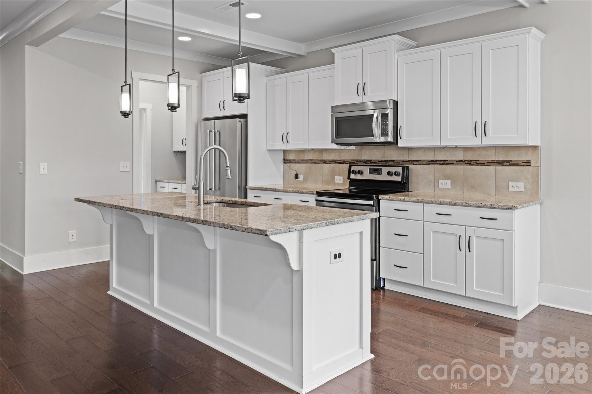 12039 Spinnaker Drive Tega Cay, SC 29708 - Photo 10 of 48 a kitchen with white cabinets and stainless steel appliances
