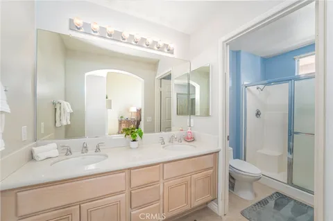 a bathroom with a double vanity sink mirror and toilet