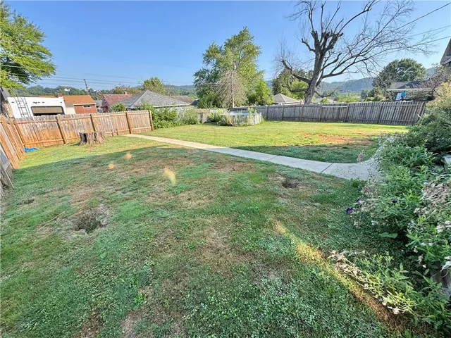 a view of swimming pool with lawn chairs and plants