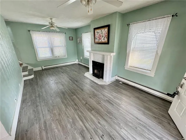wooden floor fireplace and windows in an empty room