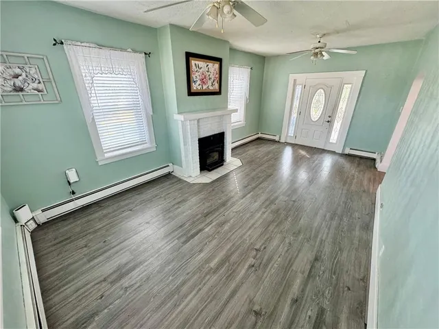 a view of a livingroom with wooden floor and a fireplace