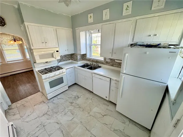 a kitchen with white cabinets and white appliances