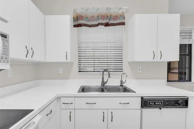 a kitchen with a sink cabinets and white appliances