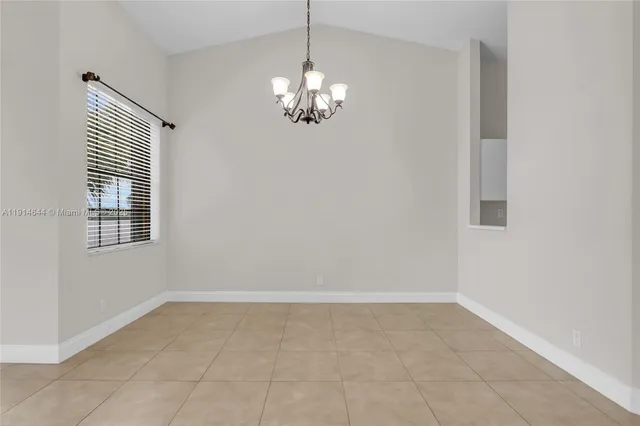 a view of kitchen with chandelier and window