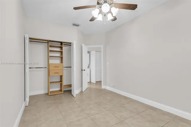 an empty room with closet and windows