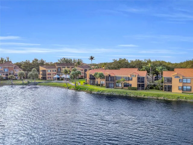 a view of a big house with a big yard and large trees