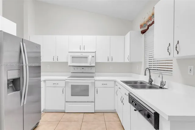 a kitchen with cabinets stainless steel appliances and a sink