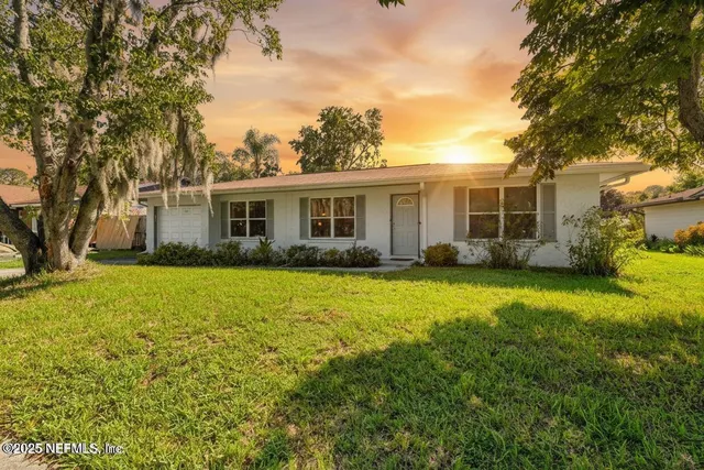 a front view of house with yard and trees around