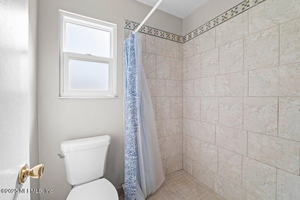 11631 East Ride Drive Jacksonville, FL 32223 - Photo 13 of 28 a white toilet sitting next to a bathroom sink