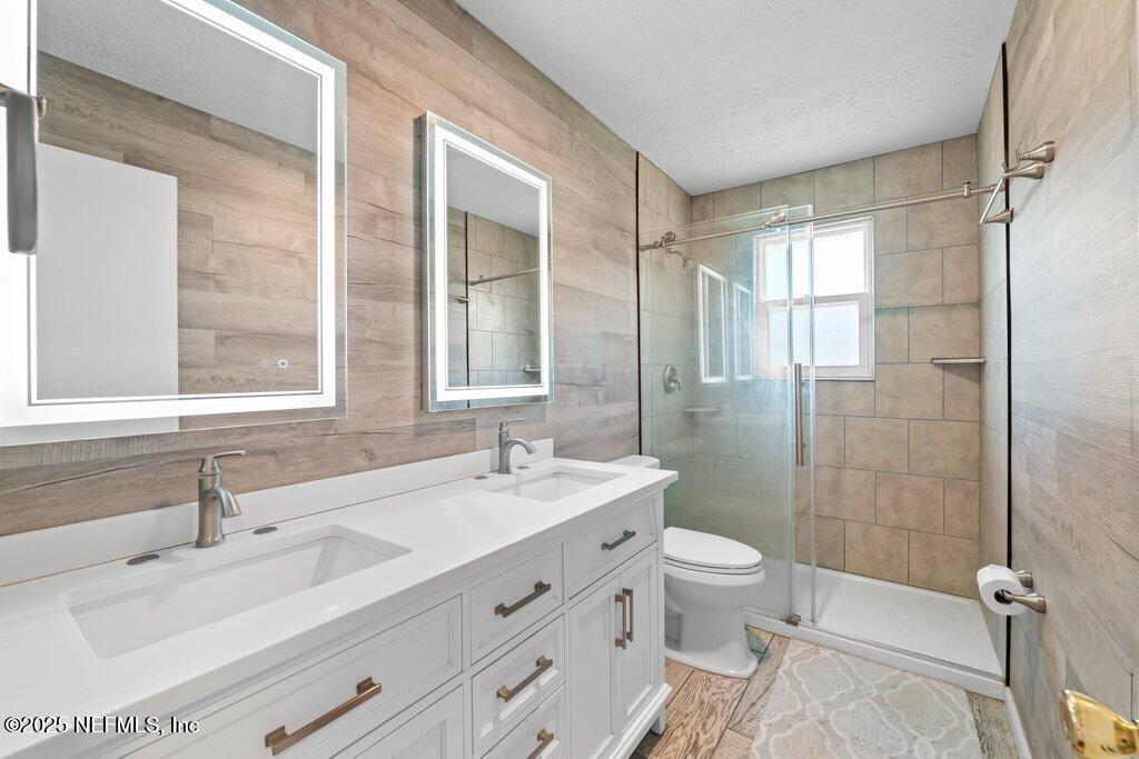 11631 East Ride Drive Jacksonville, FL 32223 - Photo 7 of 28 a bathroom with a double vanity sink toilet mirror and shower