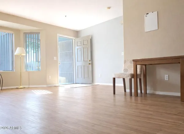 a view of an empty room with window and wooden floor