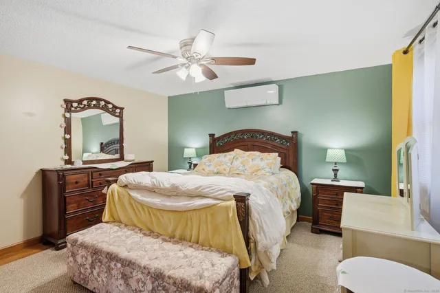 a bedroom with a bed and dresser with mirror