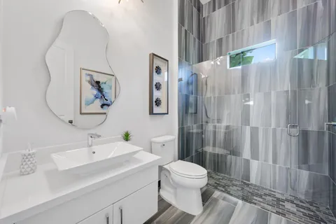 a bathroom with a double vanity sink a large mirror and a bathtub