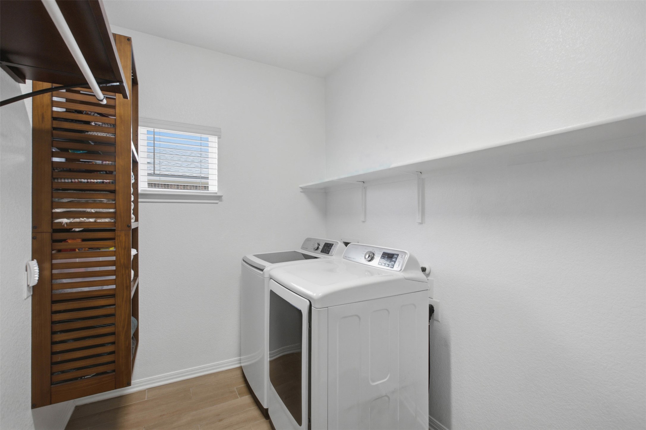 2413 Bridges Ranch Road Georgetown, TX 78628 - Photo 12 of 31 Functional laundry space featuring modern appliances and a slatted storage cabinet for essentials.