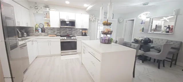 a kitchen with a white cabinets and chairs