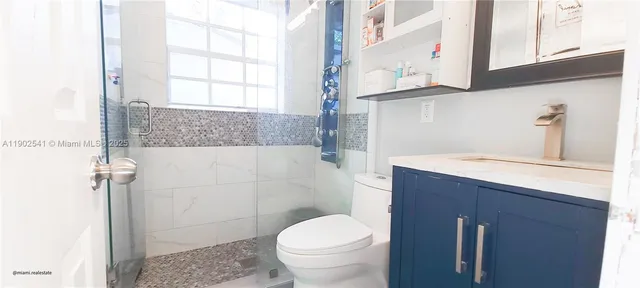 a bathroom with a granite countertop toilet sink and mirror