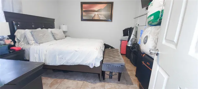 a bedroom with a bed toilet and a flat tv screen