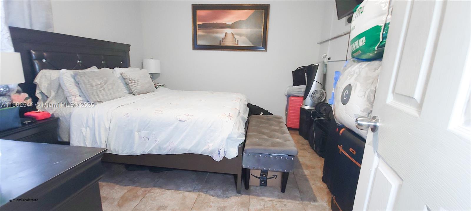 232 Northeast 160th Street Miami, FL 33162 - Photo 21 of 36 a bedroom with a bed toilet and a flat tv screen
