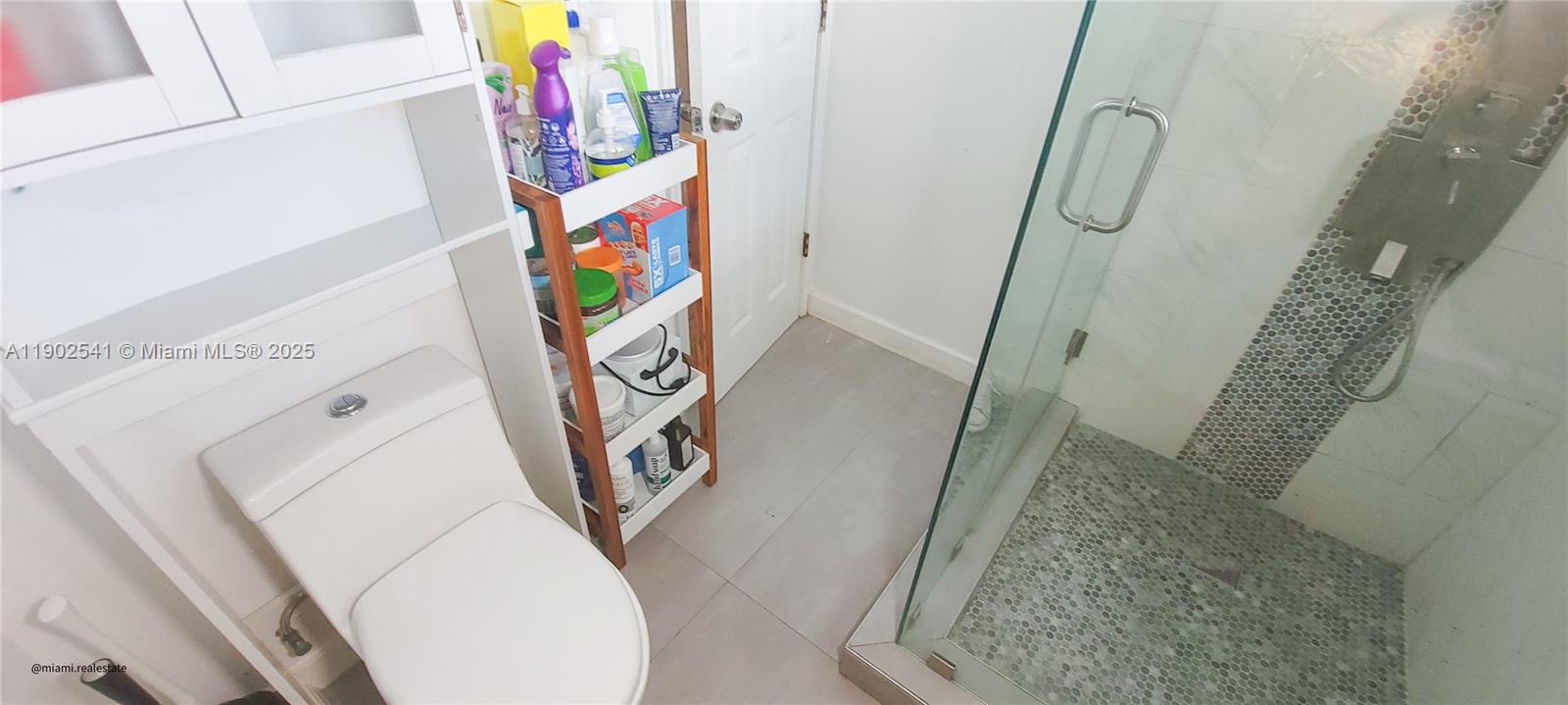 232 Northeast 160th Street Miami, FL 33162 - Photo 24 of 36 a bathroom with a toilet and a shower curtain