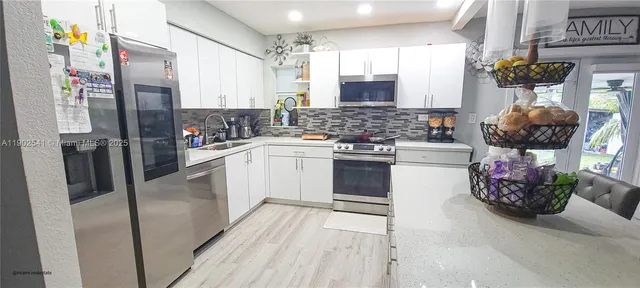 a kitchen with stainless steel appliances a stove a sink and a refrigerator