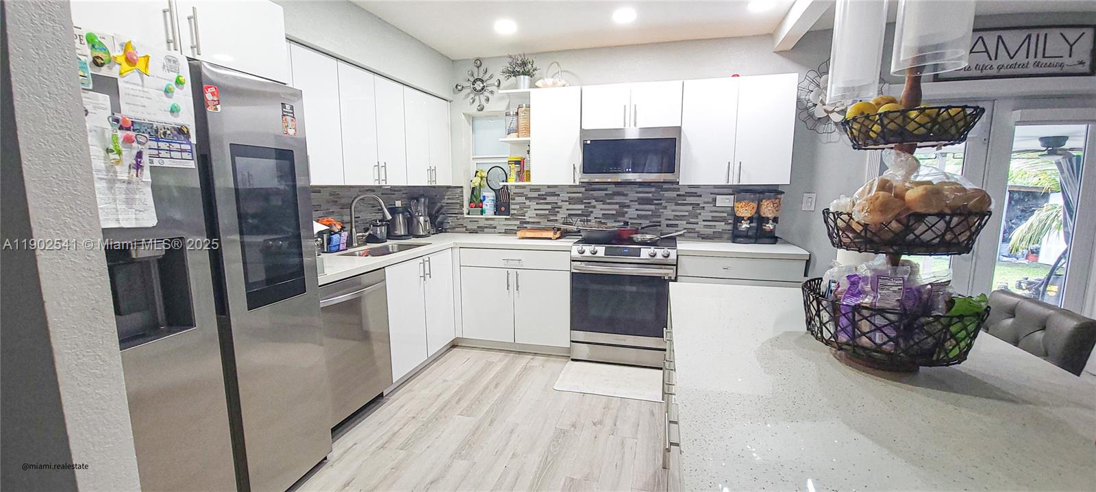 232 Northeast 160th Street Miami, FL 33162 - Photo 7 of 36 a kitchen with stainless steel appliances a stove a sink and a refrigerator
