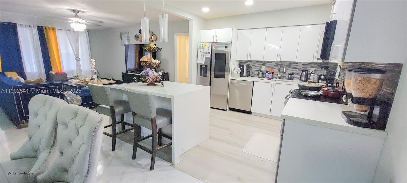 232 Northeast 160th Street Miami, FL 33162 - Photo 9 of 36 a view of kitchen and living room with a couch