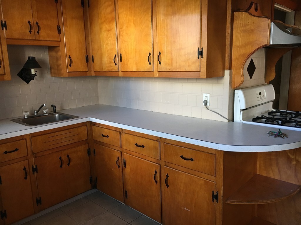 682 2nd Street Fall River, MA 02721 - Photo 3 of 12 a kitchen with stainless steel appliances granite countertop a sink a stove and cabinets