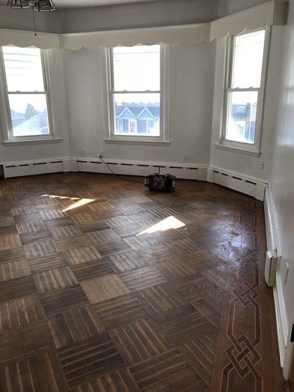 682 2nd Street Fall River, MA 02721 - Photo 6 of 12 an empty room with wooden floor and windows