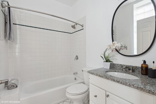a bathroom with a granite countertop sink mirror toilet and bathtub