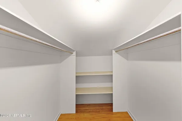 a view of walk in closet with empty racks