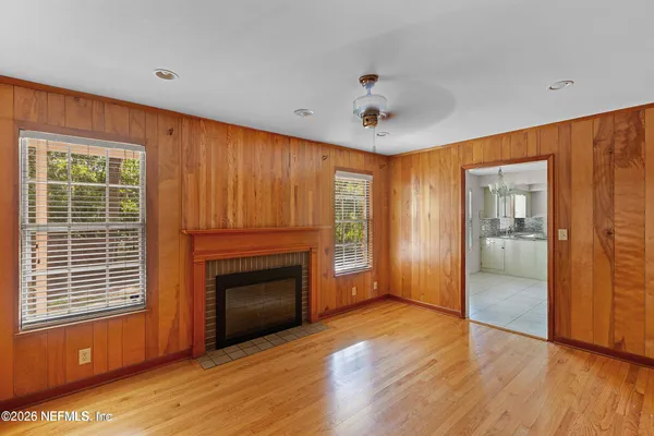 a view of a livingroom with wooden floor a fireplace and window