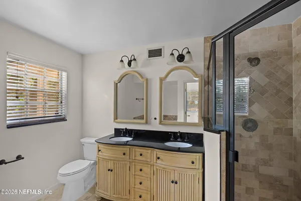 a bathroom with a granite countertop sink a toilet and a mirror