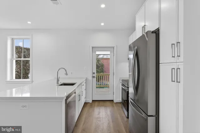 a kitchen with stainless steel appliances a refrigerator sink and cabinets