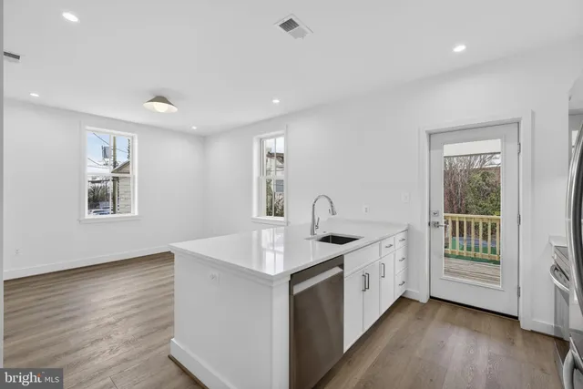a kitchen with a sink and wooden floor