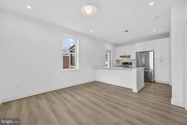 a view of kitchen with cabinets stainless steel appliances and wooden floor