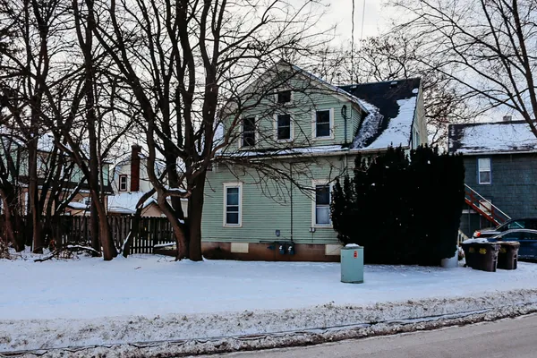 a view of a house with a yard covered in snow