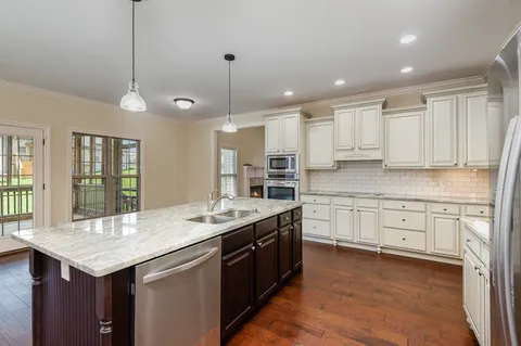 a kitchen with granite countertop kitchen island white cabinets and white appliances