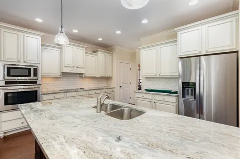 a kitchen with kitchen island a counter top space stainless steel appliances and cabinets