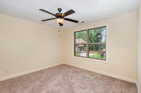 an empty room with a window and a fan