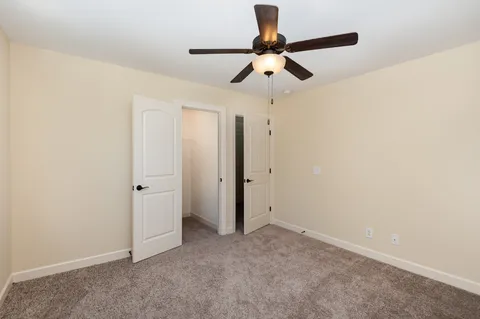 an empty room with a fan and a ceiling fan