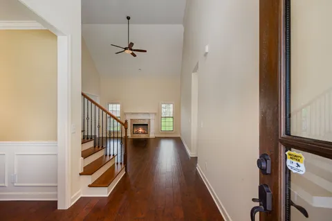 a view of a hallway with wooden floor and staircase