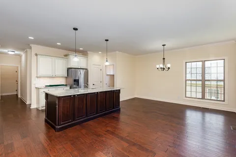 a kitchen with stainless steel appliances granite countertop a sink a stove a refrigerator and a large window