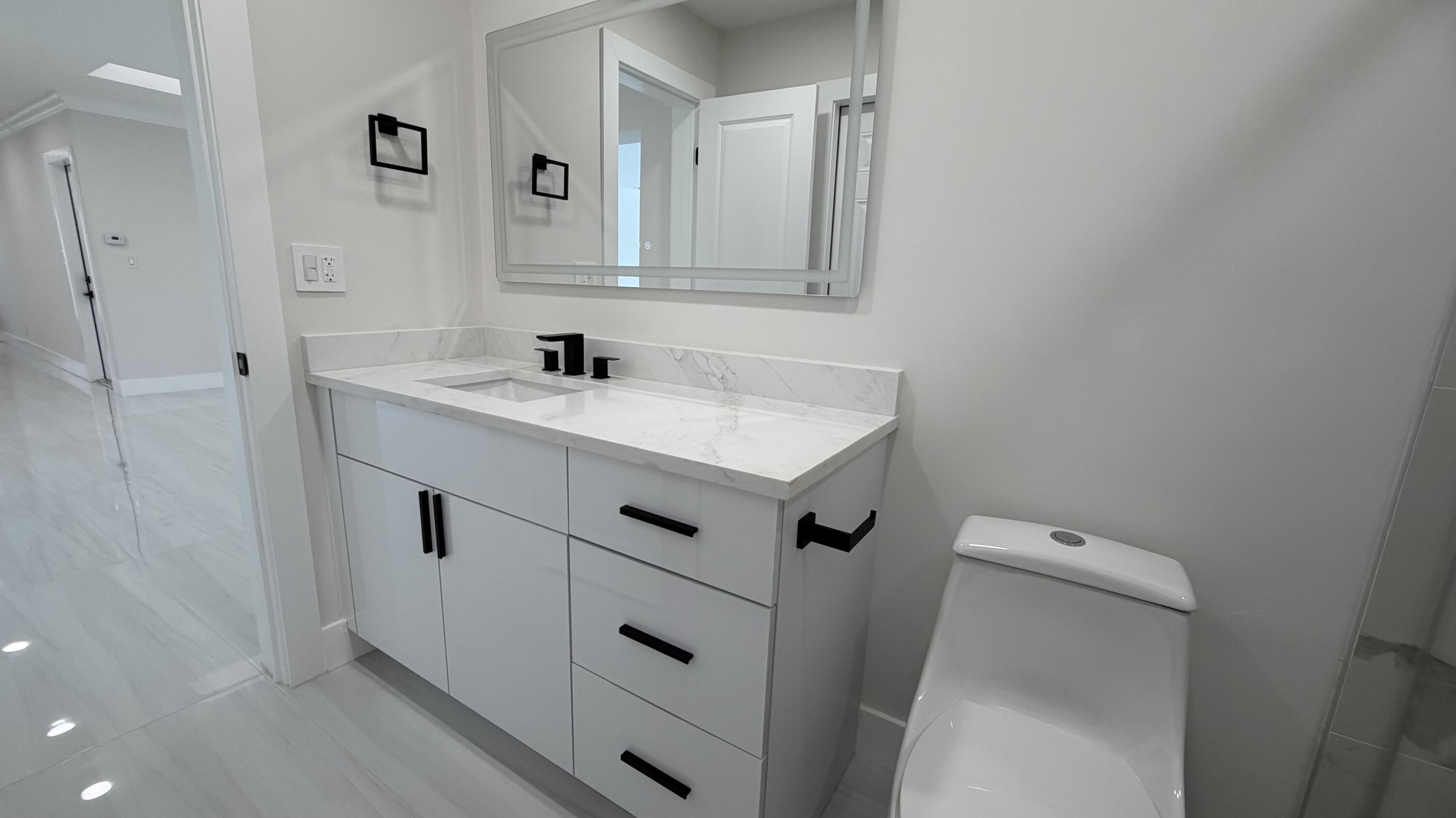 2521 Northeast 45th Street Lighthouse Point, FL 33064 - Photo 20 of 25 a view of bathroom with a sink a toilet and a mirror