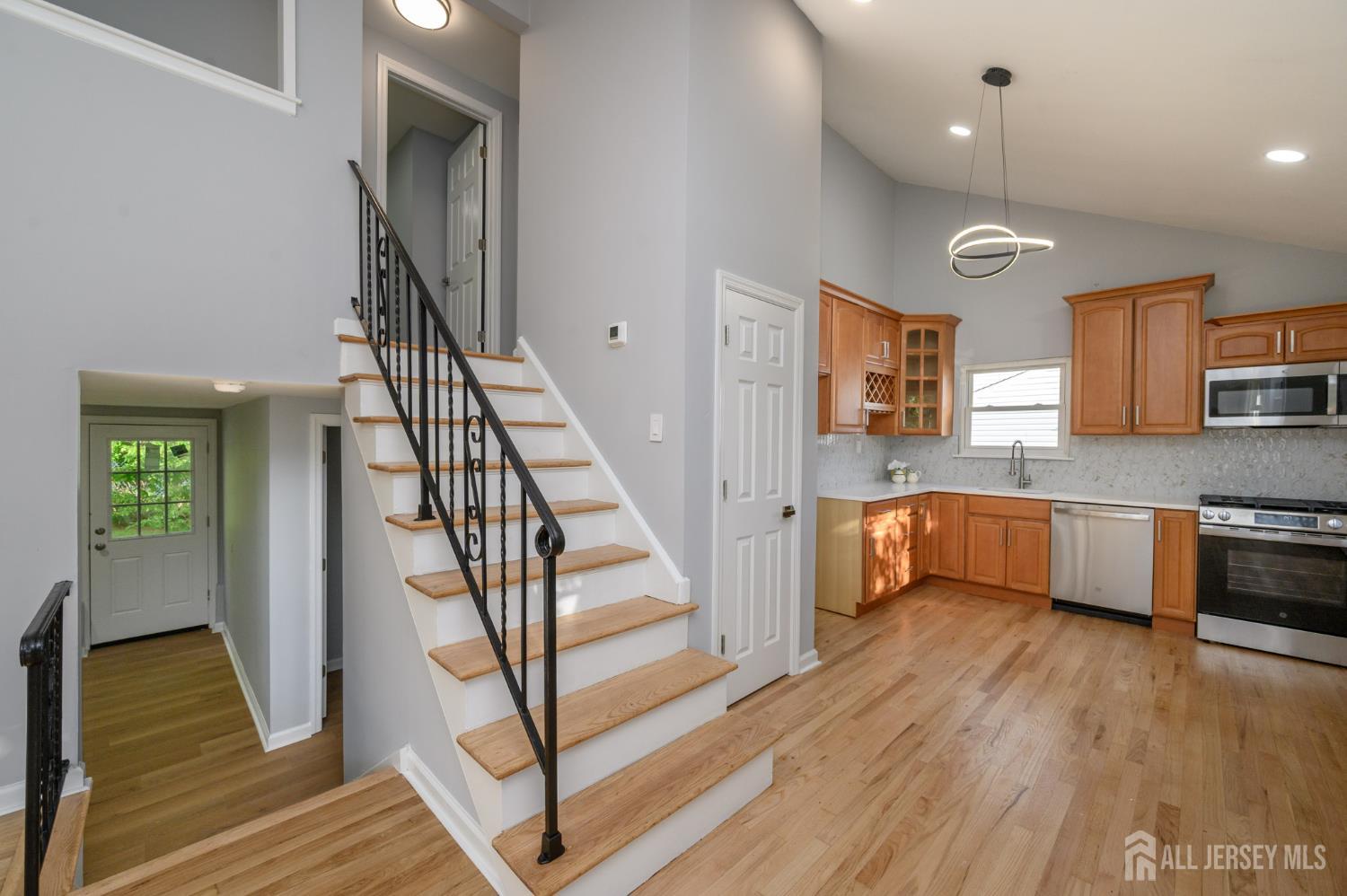 56 Drake Place Colonia, NJ 07067 - Photo 14 of 31 a kitchen with stainless steel appliances granite countertop a refrigerator a sink dishwasher a stove and white countertops with wooden floor
