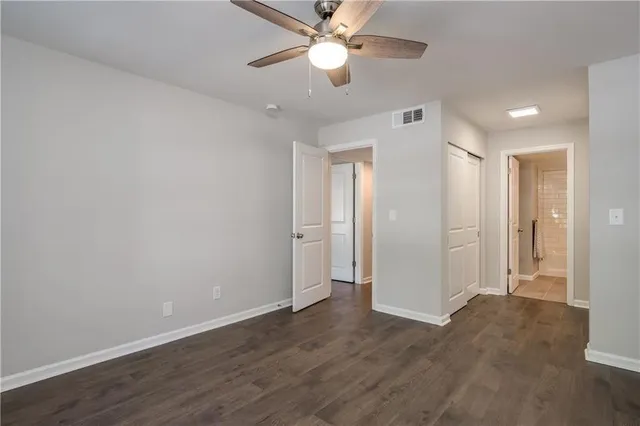 a view of an empty room and a ceiling fan window