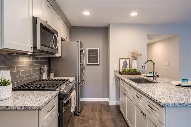 a kitchen with granite countertop stainless steel appliances and wooden cabinets