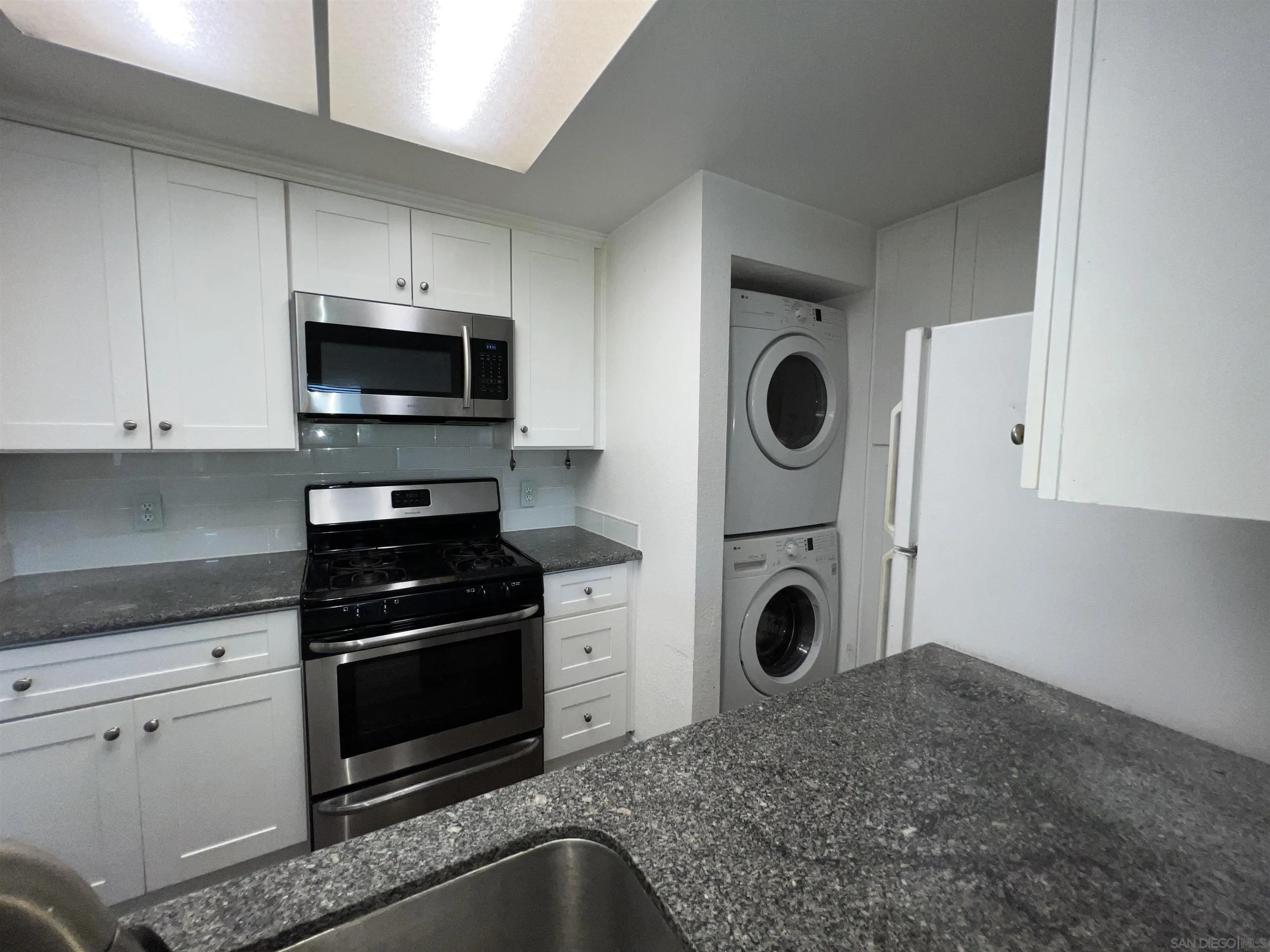 3043 Chipwood Court Spring Valley, CA 91978 - Photo 13 of 38 a kitchen with white cabinets and stainless steel appliances