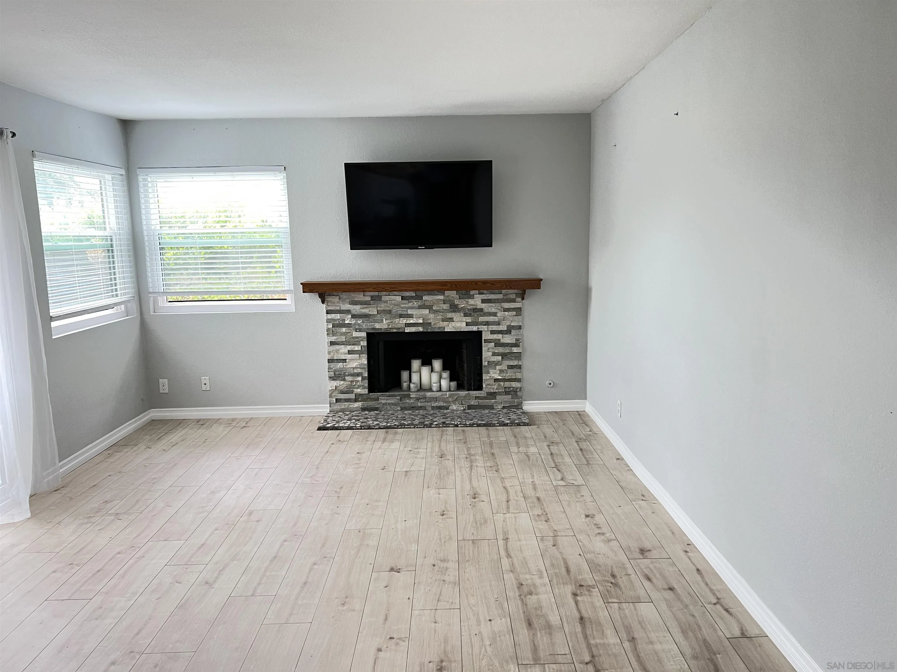 3043 Chipwood Court Spring Valley, CA 91978 - Photo 2 of 38 an empty room with windows fireplace and wooden floor